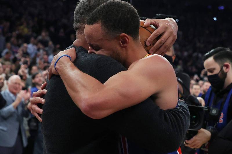NEW YORK, NEW YORK - DECEMBER 14: Stephen Curry #30 of the Golden State Warriors hugs his Dad Dell Curry after making a three point basket to break Ray Allen's record for the most all-time against the New York Knicks during their game at Madison Square Garden on December 14, 2021 in New York City. NOTE TO USER: User expressly acknowledges and agrees that, by downloading and or using this photograph, User is consenting to the terms and conditions of the Getty Images License Agreement.