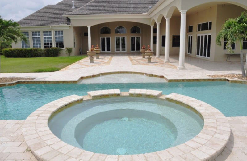 The pool and Jacuzzi sit in perfectly manicured gardens
