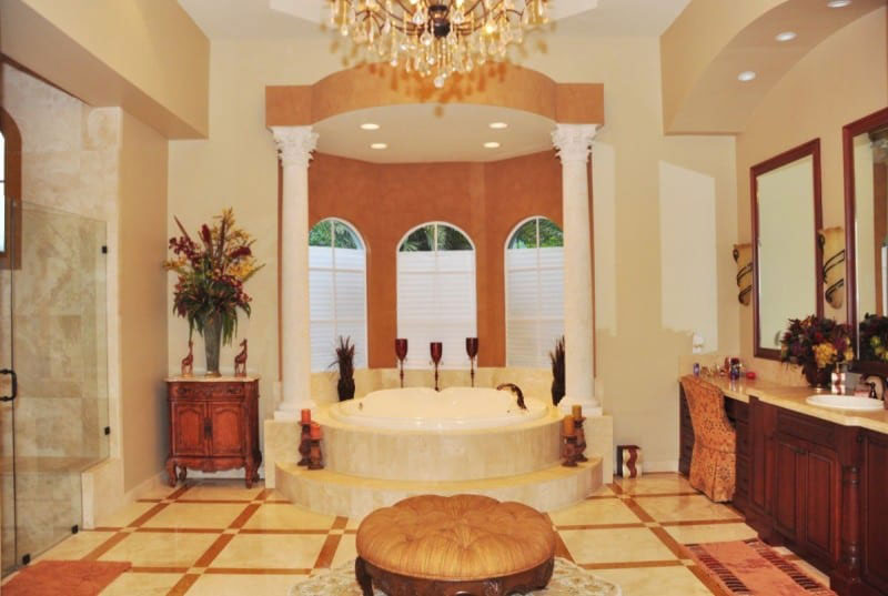 The master bathroom features a large bath surrounded by two impressive Roman-style pillars